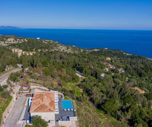 an aerial view of a house on a hill next to the ocean at Nikolakos Villa in Agios Nikolaos