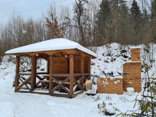 a wooden gazebo with snow on top of it at Villa Na uzlissi in Migovo