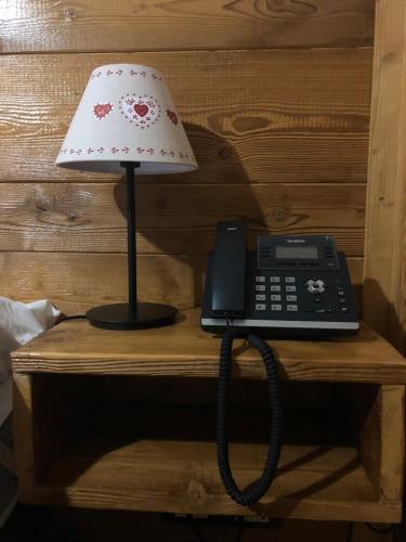 a telephone and a lamp on a wooden table at Hotel Coeur Du Village in La Thuile