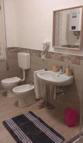 a bathroom with a toilet and a sink and a mirror at Appartamento Fiore in Bagnolo Mella