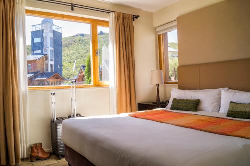 a bedroom with a large bed with a large window at Galileo Boutique Hotel in San Carlos de Bariloche