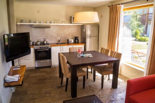 a kitchen with a dining room table and a television at Galileo Boutique Hotel in San Carlos de Bariloche