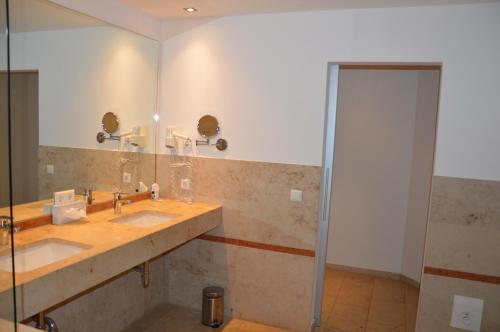 a bathroom with two sinks and a mirror at Hotel Holter Schloßkrug in Schloß Holte-Stukenbrock