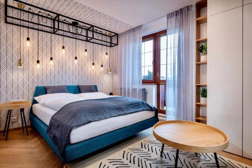 una camera con un letto blu e un tavolo di TATRYSTAY Cactus Luxury Apartment High Tatras a Veľká Lomnica