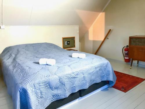 a bedroom with a blue bed with two towels on it at Fishermans Dock Lofoten in Ballstad