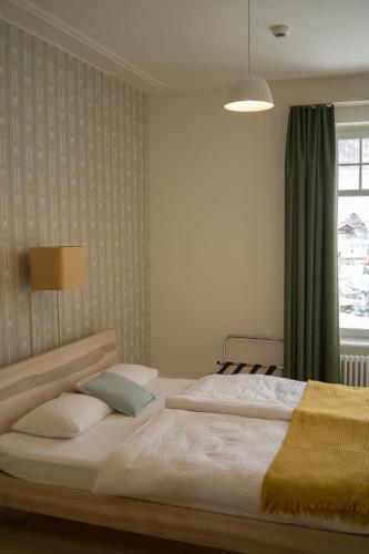 a bedroom with a large bed and a window at Hotel Erica in Langenbruck