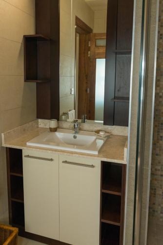 a bathroom with a white sink and a mirror at Villasun Luxury Apartments & Villas in Flic-en-Flac