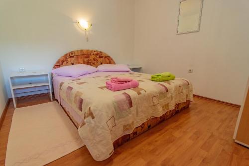 1 dormitorio con 1 cama grande con almohadas rosas en Apartment Dumičić 2 en Rab