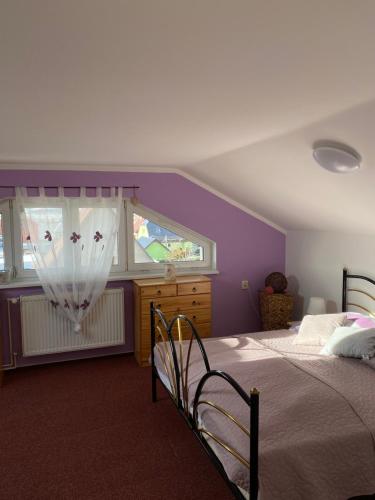 a bedroom with a large bed and a window at Penzion SLUNCE in Česká Lípa