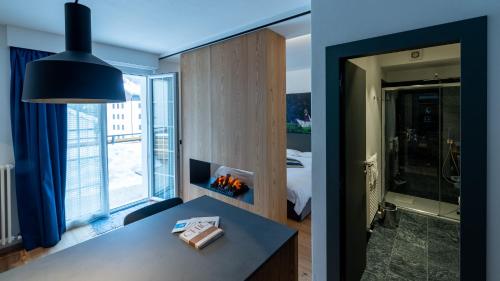 a room with a desk and a room with a bedroom at Sport Hotel Alpina in Madesimo