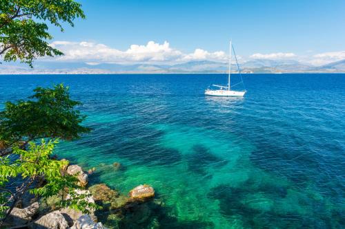 a boat in the middle of a large body of water at Porto Kassiopi Apartments in Kassiopi