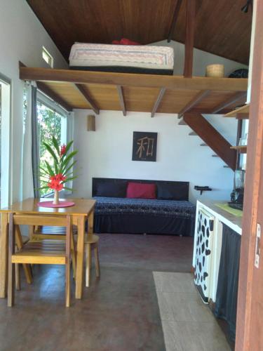 Cette chambre comprend une mezzanine, une table et un canapé. dans l'établissement Casa Shuhari, à Morro de São Paulo