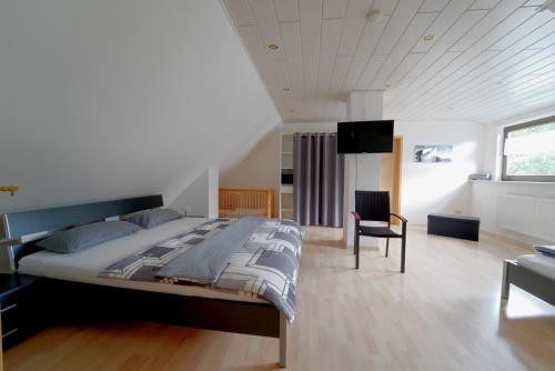 1 dormitorio con 1 cama grande y 1 silla en Ferienwohnung Hoffmann - Eifel en Nimshuscheid