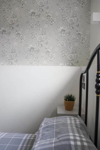 a bedroom with a bed and a plant on a wall at Burren London Hotel in London