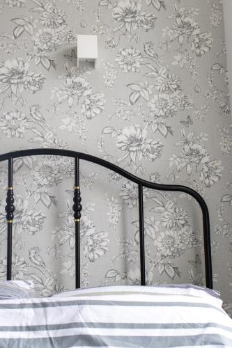 a bedroom with a bed with a floral wallpaper at Burren London Hotel in London