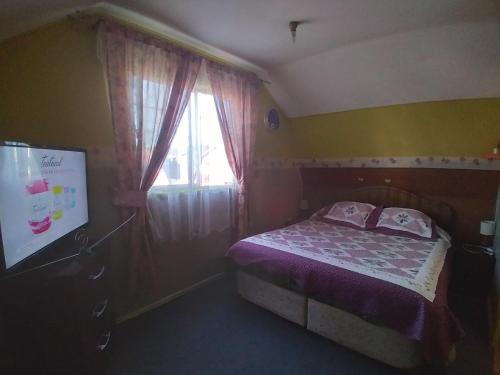 a small bedroom with a bed and a window at CASA in Puerto Montt