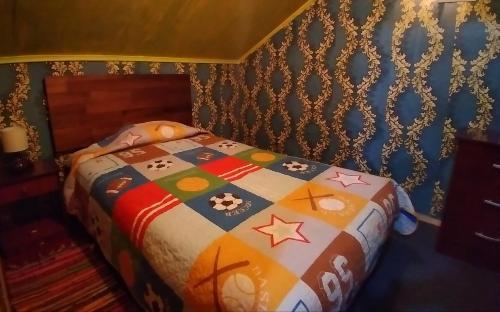 a bed with a colorful quilt on it in a room at CASA in Puerto Montt