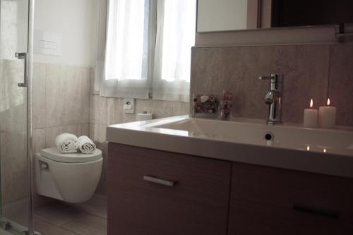 een badkamer met een wastafel en een toilet met kaarsen bij Garnì Stella Marina in Cervia