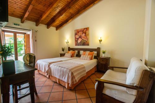 a bedroom with two beds and a table and chairs at Monte Joao Roupeiro - Turismo Rural in Odeceixe