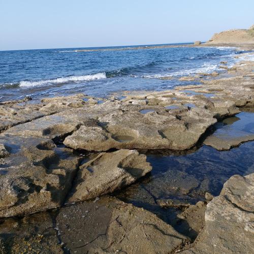 a rocky shoreline with the ocean in the background at Vouni King Hotel in Limnitis