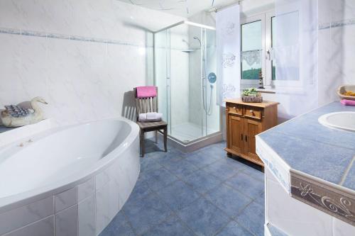 een badkamer met een bad, een douche en een wastafel bij Siglbauernhof in Laufen