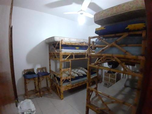 a room with three bunk beds and a ceiling at Meu Cantinho in Itanhaém