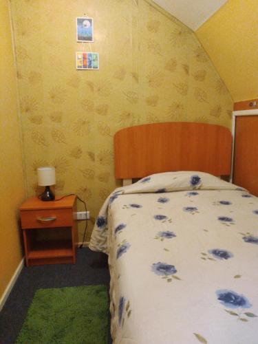 a bedroom with a bed and a wooden headboard and a table at CASA in Puerto Montt