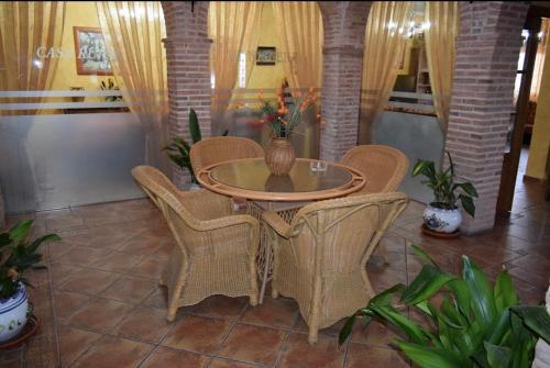 a table with wicker chairs and a vase on it at Casa Rural La Higuera I Puy du Fou in Pulgar