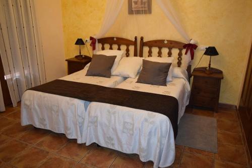 a bedroom with a large bed with two pillows at Casa Rural La Higuera I Puy du Fou in Pulgar