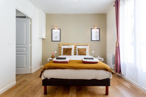 une chambre avec un lit avec deux oreillers dessus dans l'établissement StayLib - Lovely 2 rooms porte de Montmartre, à Saint-Ouen