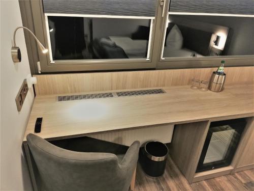 escritorio y silla en una habitación con espejo en Hotel & Restaurant Alte Molkerei Kölleda en Kölleda