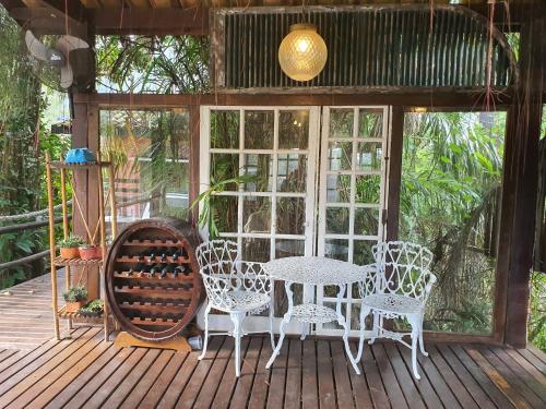 a patio with a table and chairs on a deck at Chalés Catavento in Maresias