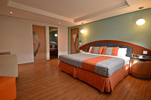 a bedroom with a large bed in a room at Hotel Catalina in Mexico City