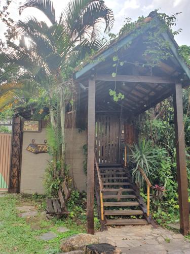 a building with a wooden staircase and a blue umbrella at Chalés Catavento in Maresias