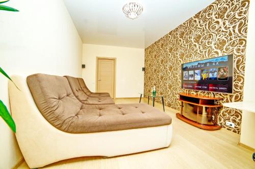 - un salon avec un canapé et une télévision dans l'établissement Alex Apartment Сеть апартаментов Бесконтактное заселение 24-7, à Poltava