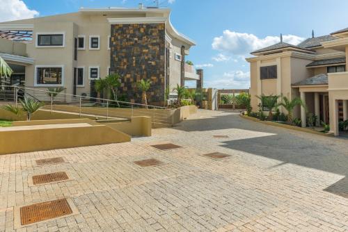 a brick walkway in front of a building at Villasun Luxury Apartments & Villas in Flic-en-Flac