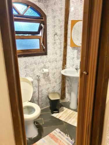 a bathroom with a toilet and a sink at Chalés Catavento in Maresias