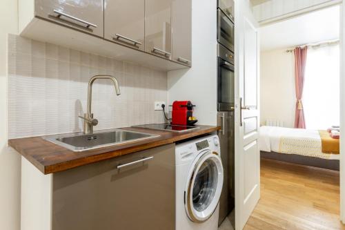 une cuisine avec un évier et une machine à laver dans l'établissement StayLib - Lovely 2 rooms porte de Montmartre, à Saint-Ouen