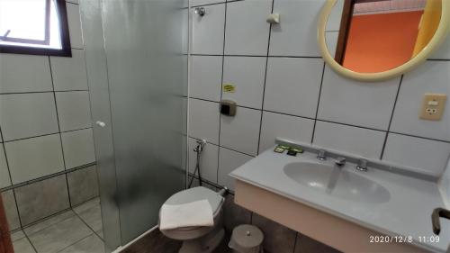 a bathroom with a sink and a toilet and a mirror at Pousada Ecomar in Florianópolis