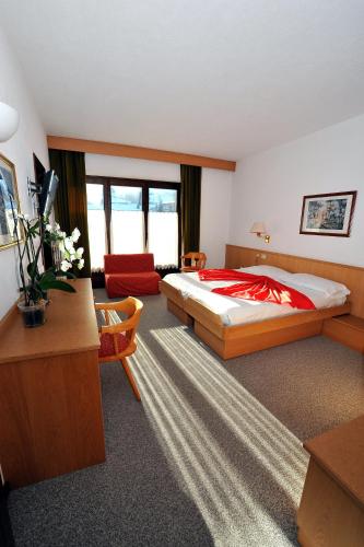 a bedroom with a bed and a living room at Hotel Derby in Bormio