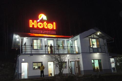 a hotel with a neon sign on top of it at night at Hotel Mount Paradise in Nagarkot