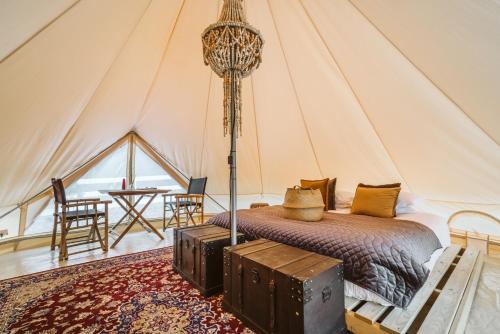 um quarto com uma cama numa tenda em The Woods Farm Jervis Bay em Tomerong