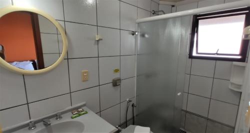 a bathroom with a sink, toilet and mirror at Pousada Ecomar in Florianópolis