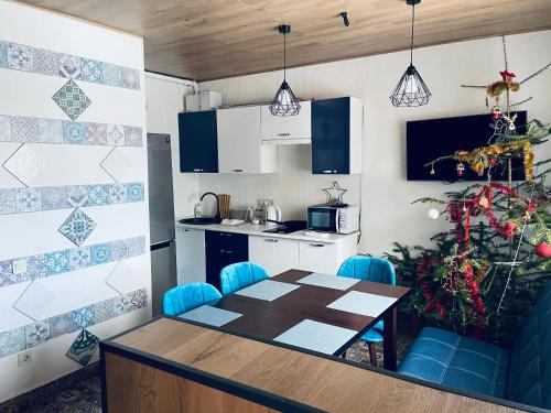 a kitchen with a table and blue chairs in a room at DanRock in Yablunytsya