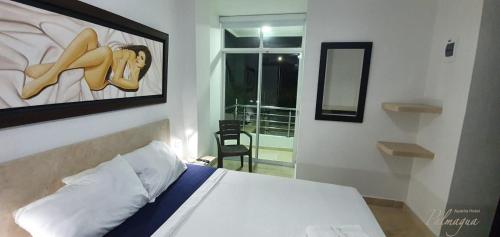 a bedroom with a bed with a painting of a woman at Palmagua in Barranquilla