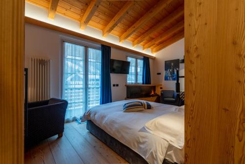 a bedroom with a large bed and two windows at Sport Hotel Alpina in Madesimo