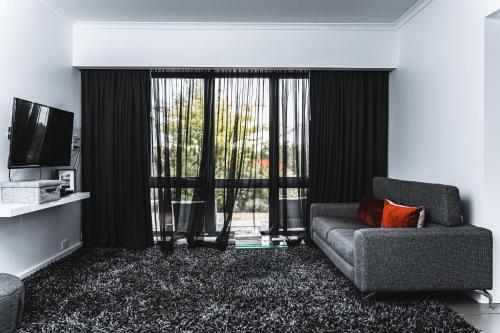 a living room with a couch and a television at Daylesford Spa Accommodation in Daylesford
