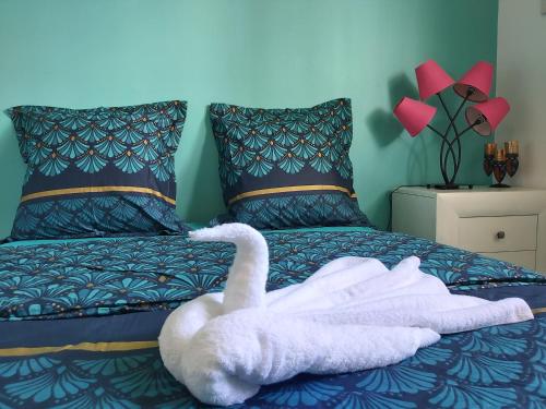 a white swan is laying on a bed at Appartement face à la marina du marin martinique in Le Marin