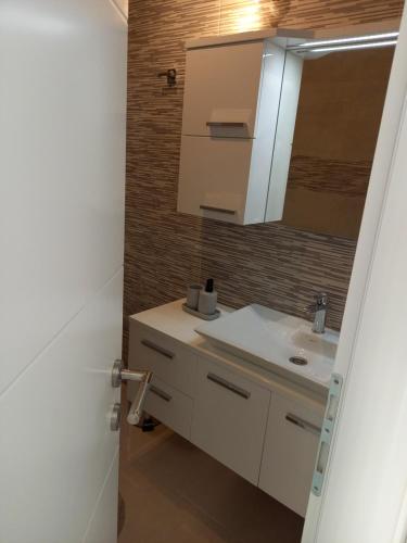 a bathroom with a white sink and a mirror at Premier House by RD Group in Korenica