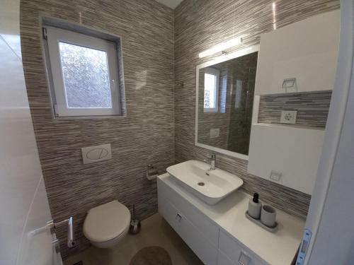a bathroom with a sink and a toilet and a mirror at Premier House by RD Group in Korenica